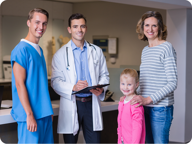 Happy collaborative medical care team standing alongside little child family member